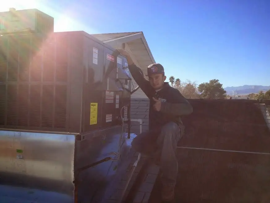 HVAC technician performing HVAC Inspection on a rooftop unit in San Luis